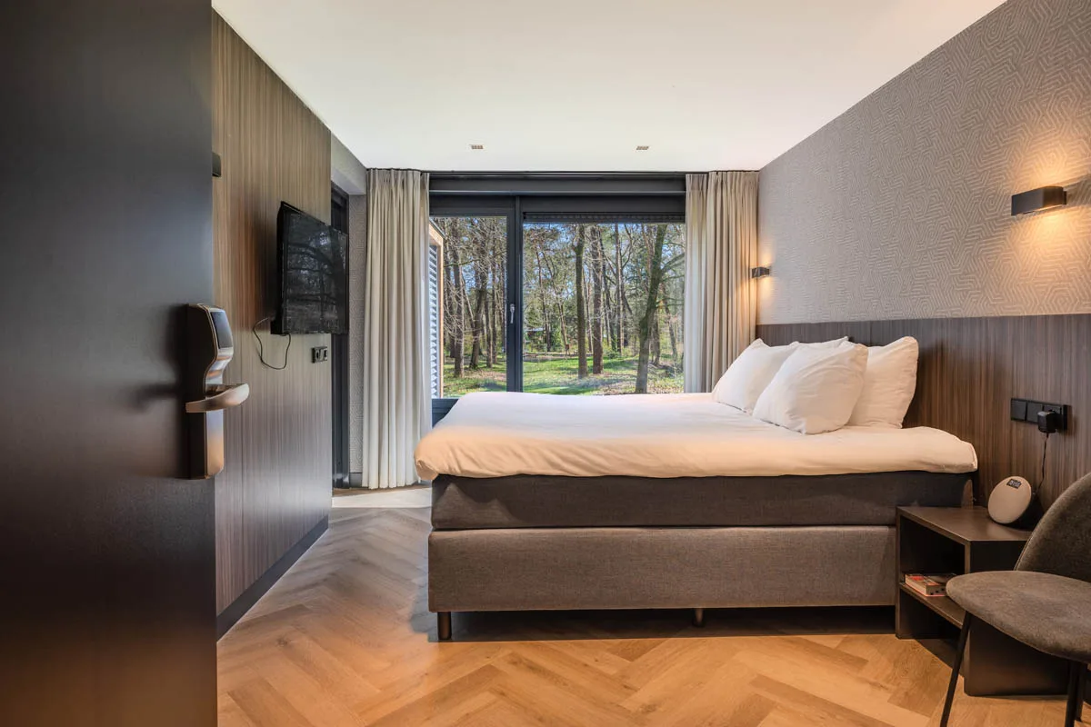 Moderne hotelkamer bij De Werelt in Lunteren met uitzicht op het bos van de Veluwe